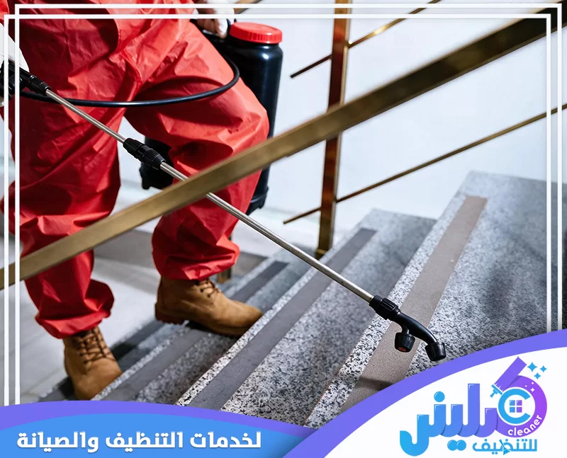 فني مكافحة حشرات يرتدي بدلة واقية ويرش المبيدات على درجات السلم باستخدام بخاخ احترافي.