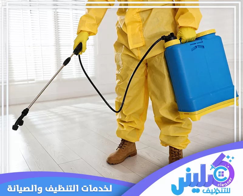 فني مكافحة حشرات يرتدي بدلة واقية ويرش المبيدات داخل المنزل باستخدام معدات متخصصة.