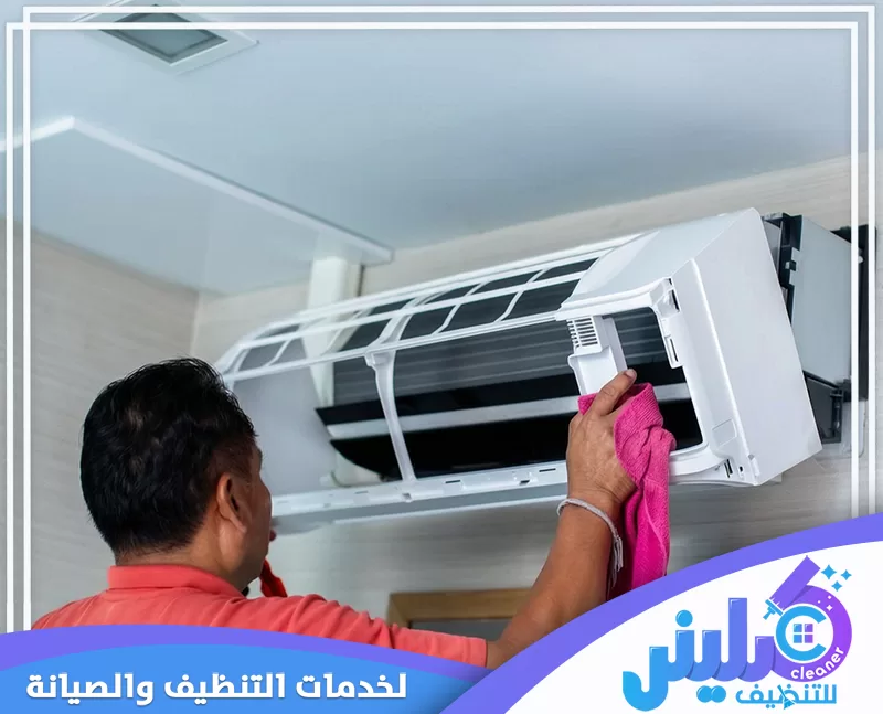 فني يقوم بتنظيف الوحدة الداخلية لمكيف سبليت باستخدام قطعة قماش ضمن خدمة تنظيف مكيفات بالخبر.