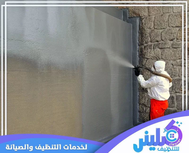 فني متخصص يرش طبقة عزل مائي على الجدران لحماية المبنى من الرطوبة والتسربات.