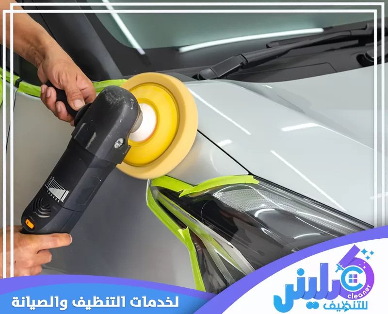 تلميع طلاء السيارة باستخدام ماكينة بوليش كهربائية مع حماية حواف الكشاف بشريط لاصق أثناء معالجة سطح البودي واستعادة اللمعان.